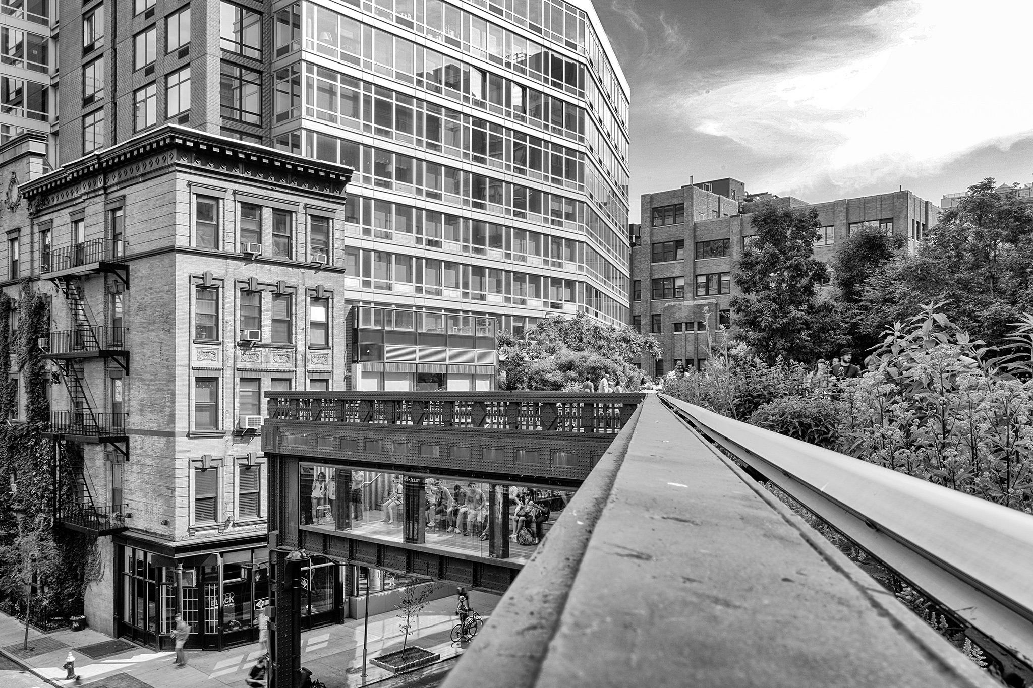 Erhöhter Parkweg zwischen Backstein- und Glasbauten